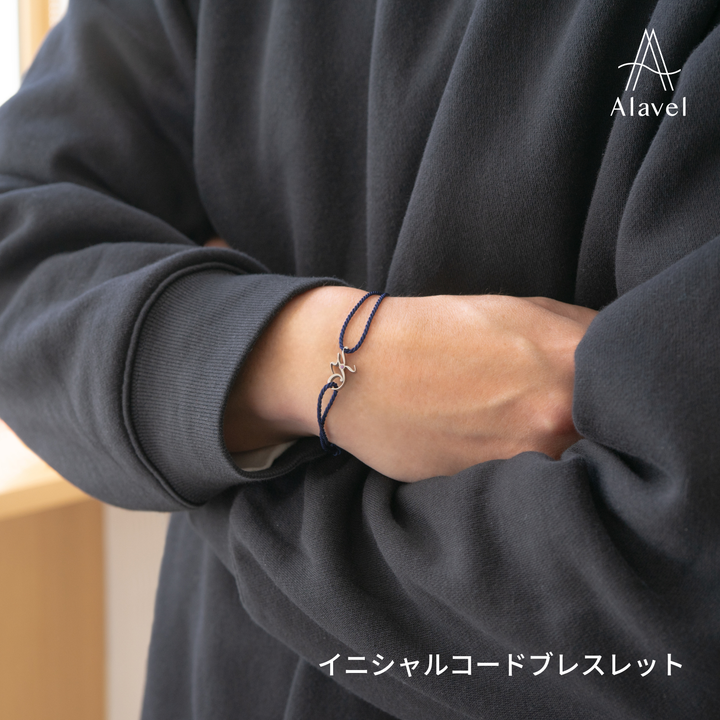ネイビーのコードブレスレットを着用した人物