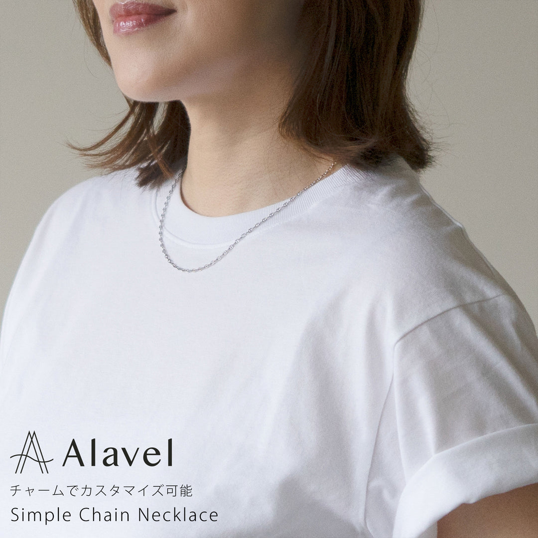 女性が白いTシャツを着て、シンプルなシルバーのチェーンネックレスを着用