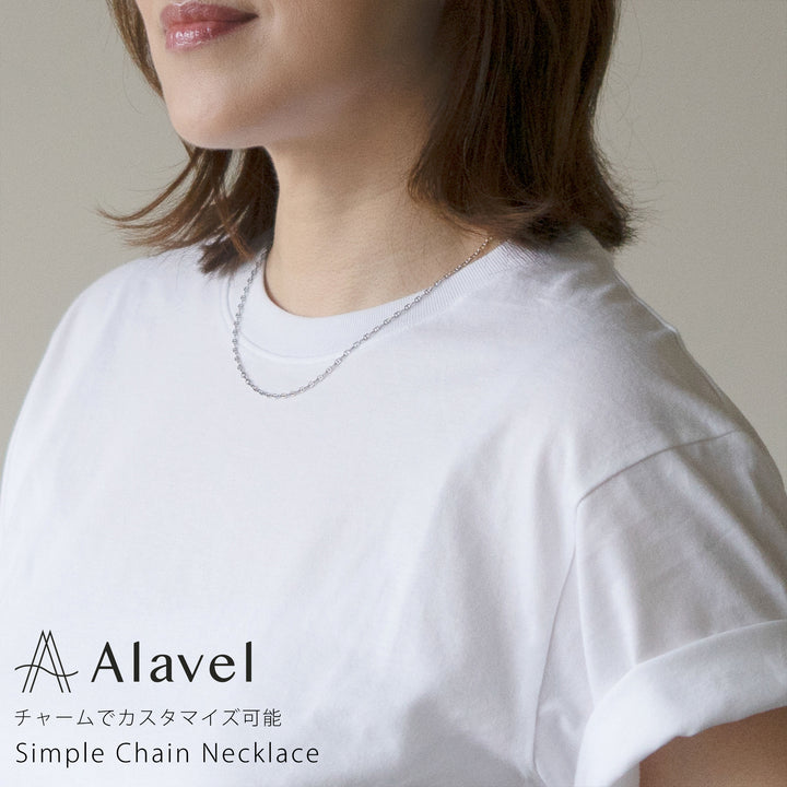 女性が白いTシャツを着て、シンプルなシルバーのチェーンネックレスを着用