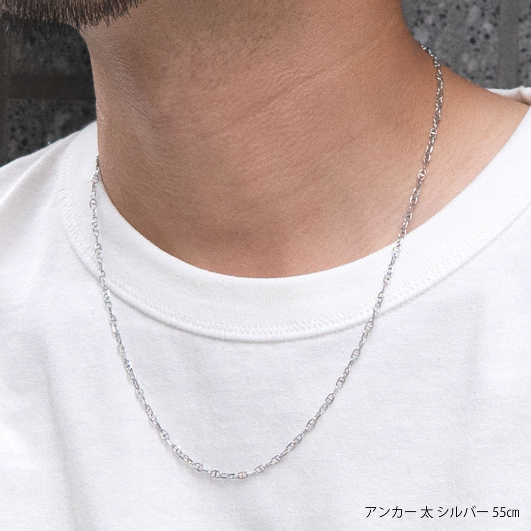 白いTシャツを着用した男性の首元に装着されたシルバーのアンカーチェーンネックレス