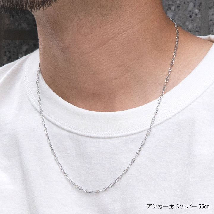 白いTシャツを着用した男性の首元に装着されたシルバーのアンカーチェーンネックレス