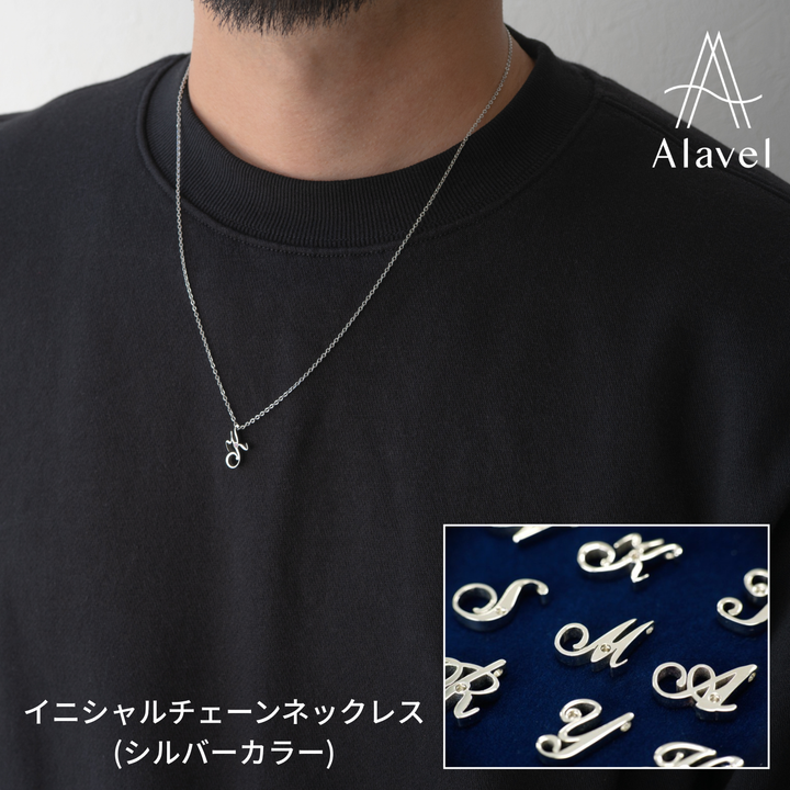 男性が黒いスウェットシャツを着て、シルバーのイニシャルネックレスを着用。右下には様々なイニシャルのクローズアップ